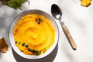 Autumn pumpkin puree in a bowl. Vegetarian autumn pumpkin cream soup with thyme
