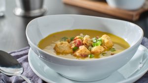 butternut squash soup in bowl with croutons bacon and scallions